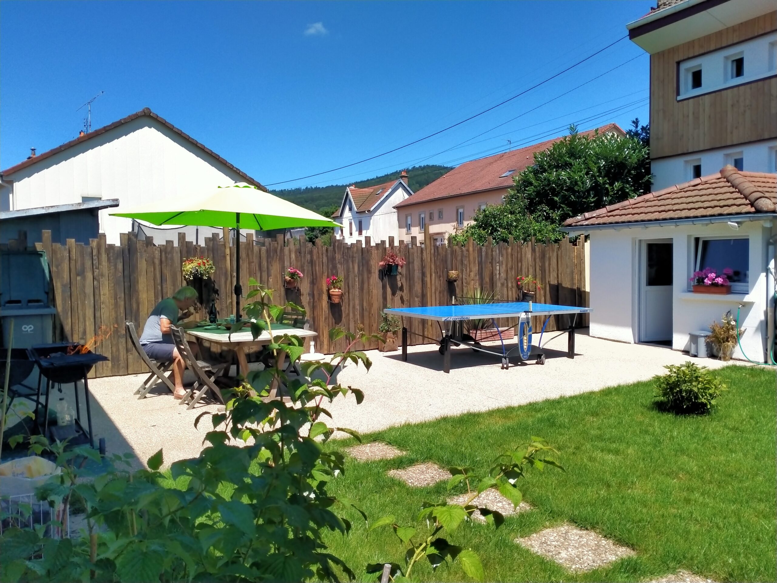 Terrasse ensoleillée avec table et parasol